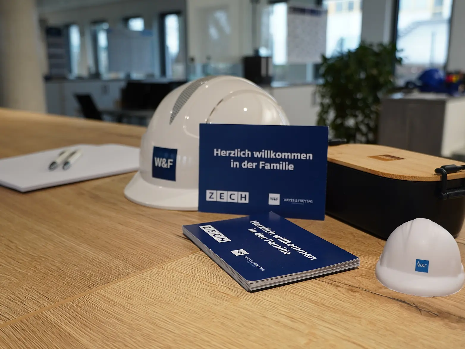 Auf einem Regal liegt ein W&F Helm und eine Willkommenskarte.