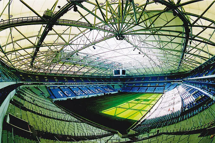 Eine Fußballarena und in der Mitte das große grüne Spielfeld.