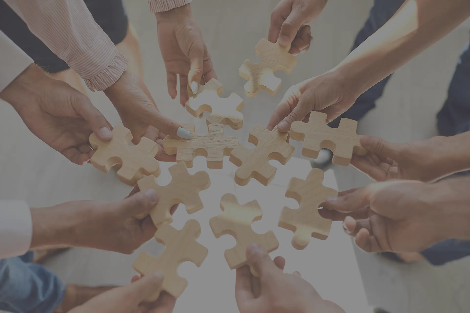 Viele Hände, die Puzzleteile halten.
