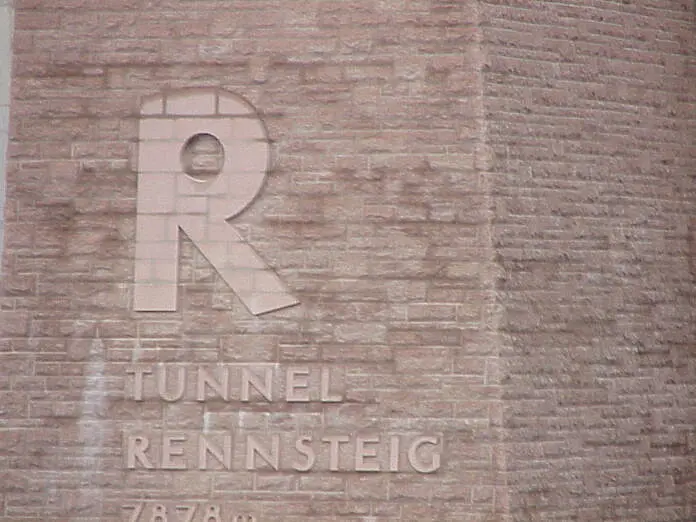Ein großes R auf steinigen Grund an der Mauer eines Tunnels.