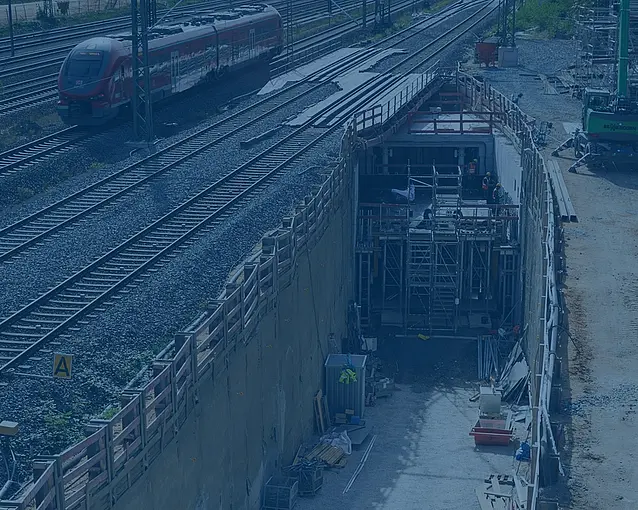 Eingang eines Tunnels neben Gleisen.