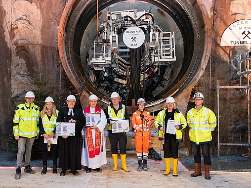 Mehrere Personen stehen vor der Öffnung eines Tunnels.