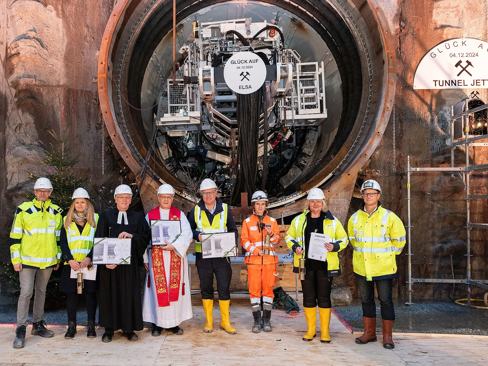 Mehrere Personen stehen vor der Öffnung eines Tunnels.