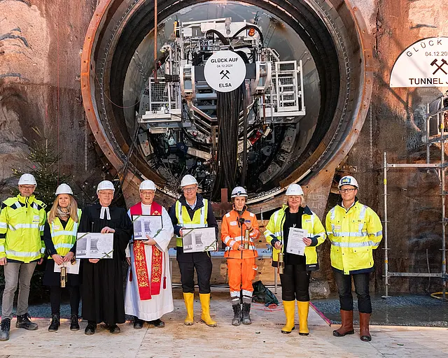 Mehrere Personen stehen vor der Öffnung eines Tunnels.