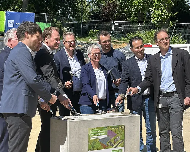 Eine Gruppe Beteiligter posiert für ein Foto zur Grundsteinlegung. 