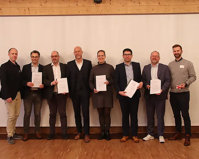 Personen halten Zertifikate.