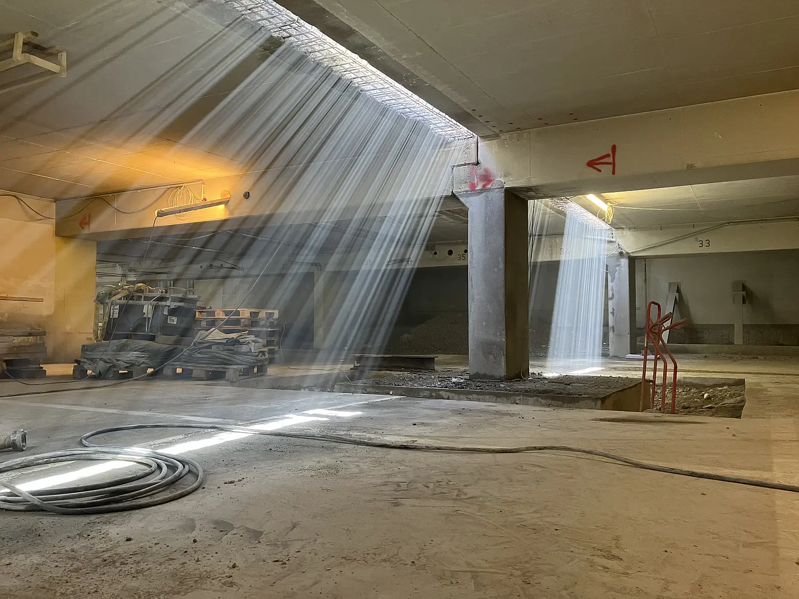 Durch die Decke einer Tiefgarage schimmert ein Lichtstrahl.